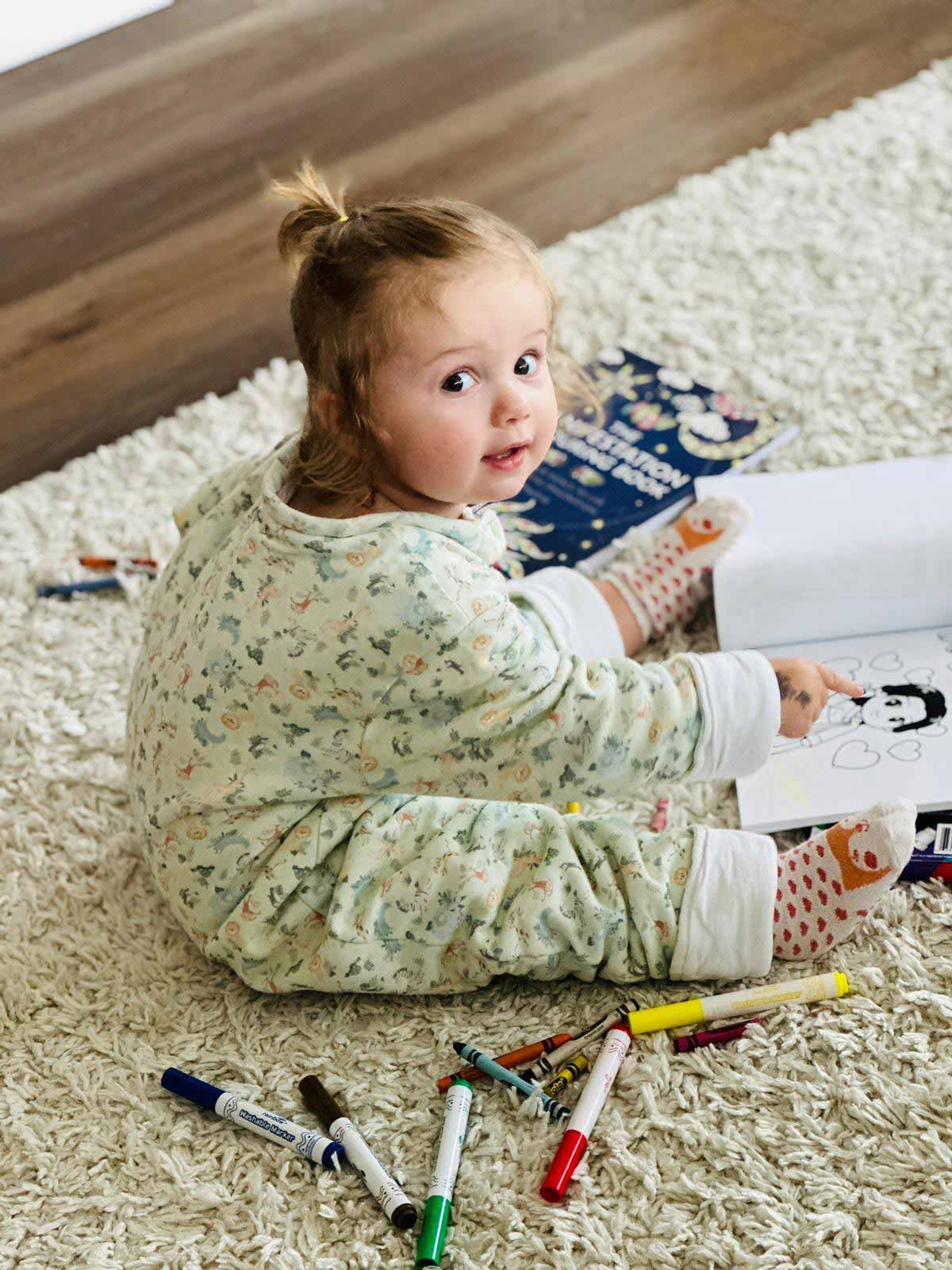 Kid pointing at a coloring book page from The Joy in You