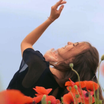 Woman stretching arms outdoors representing joyful self-care habits